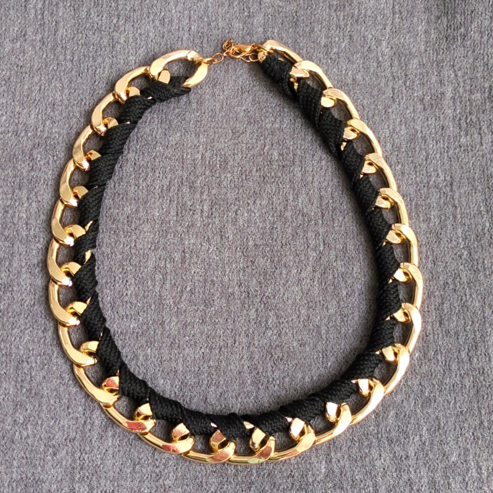 Gold chain with interwoven black ribbon